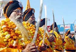 Wearing traditional garments, Sikhs carry swords during a religious procession