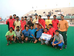 The members of Bharat Petroleum posing with the trophy of Indian Oil Cup after winning the 19th Indian Oil Surjit Hockey Tournament