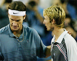 Juan Carlos Ferrero of Spain speaks with compatriot Carlos Moya