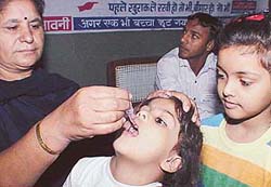 A Health Department official administers polio vaccine to a child, as another one waits for her turn, in General Hospital, Panchkula, on Sunday. 