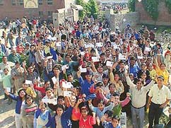 Agitated school students wave identity cards while raising slogans against the Aryabhatta Educational Society, Sector 41, in Chandigarh, on Sunday. 