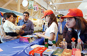 Visitors look at the products in a stall