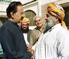 Makhdoom Amin Fahim, party leader of former Prime Minister Benazir Bhutto's Pakistan People's Party, shakes hands with Fazlur Rehman