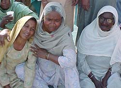 An elderly woman consoles a victim's relative