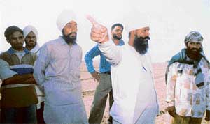 Sukhdev Singh, an allottee of the land, talks to mediapersons in Garcha village 