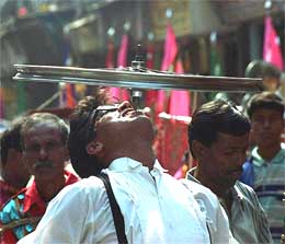 A roadside showman rotates a bicycle wheel