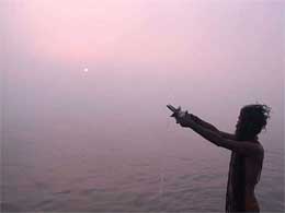 A sadhu prays to God before taking a holy dip