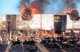 A passenger bus burns after a petrol can placed behind the drivers' seat caught fire