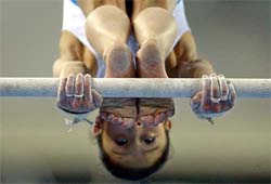 Xin Kang of China performs in the women's uneven bars competition