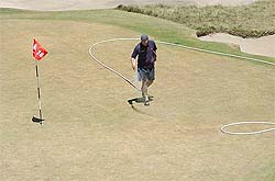 A groundsman waters the 14th green during day one of the Australian Open Golf Championship