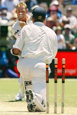 Australia's Shane Warne (L) reacts after dismissing England Batsman Andy Caddick