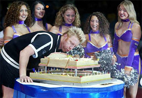 Three-time Wimbledon champion Boris Becker, surrounded by cheer leaders, blows out candles