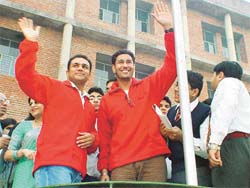 Cricketer Virender Sehwag and singer Harbhajan Mann acknowledge the greetings of students at Kundan Vidya Mandir