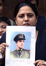 Nandita, an Indian woman, holds a photograph of her missing father