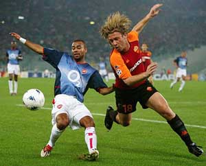 Arsenal's Ashley Cole (L) and AS Roma's Antonio Cassano follow the ball during their Champions League second phase group B match