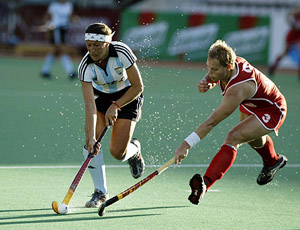 Argentina's captain Karina Masottagetting passes Denise Klecker of Germany