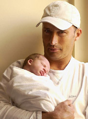 England cricket captain Nasser Hussain holds his newborn son Joel in Perth on Wednesday.