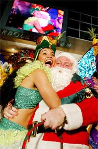 Santa Claus hugs a Samba dancer outside a shopping mall in Hong Kong
