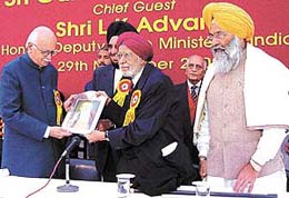 Dr Bhai Mohan Singh, president of the International Punjabi Society, and Mr P. S. Bedi, general secretary, presenting a portrait of Guru Nanak Devji to deputy Prime Minister L. K. Advani at a function to celebrate the Prakash Utsav of the Guru