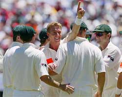 Australian bowler Brett Lee points to the crowd in celebration after dismissing England's Marcus Trescothick