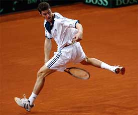 Russia's Marat Safin jumps as he makes a backhand return