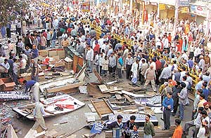 Agitated traders gather outside their demolished shops in the congested Chandni Chowk area of the walled city