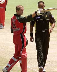 Zimbabwe batsman Grant Flower acknowledges the greetings after scoring his century as he walks past Pakistan bowler
