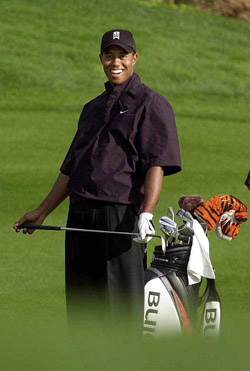 Tiger Woods smiles after making a putt