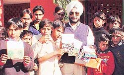 Mr Inderjit Singh Sandhu, Additional Deputy Commissioner, launches New Year cards prepared by slum children in Government High School