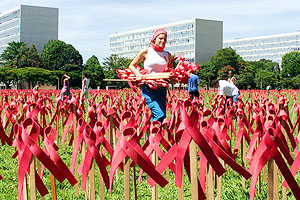 A student walks on a lawn covered by red ribbons