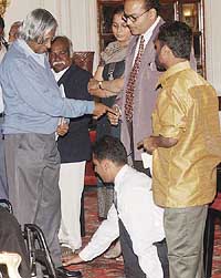 A physically handicapped person seeks the blessing of President APJ Abdul Kalam