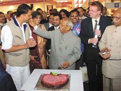 Union Minister of State for Commerce and Industry Rajiv Pratap Rudy accepts cake from Delhi Minister of Industry Deep Chand Bandhu
