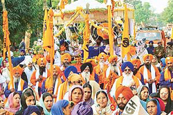 Devotees participate in a procession taken out on the eve of the martyrdom day of Guru Tegh Bahadar