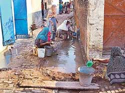 Women of Khijargarh-Kanour village, near Banur, flush out sullage from houses after collecting it in a street.