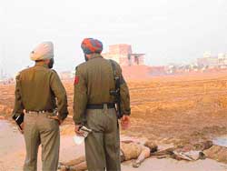 Policemen inspect the crime site at Phullanwal village