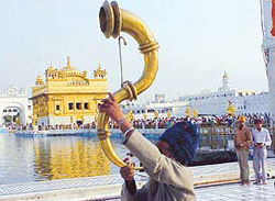 A devotee plays the Narsingha, a traditional instrument, at the Golden Temple