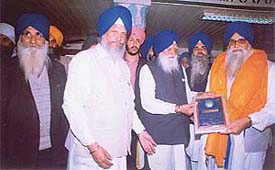 The SHSAD chief, Mr Gurcharan Singh Tohra, flanked by Mr Hira Singh Gabria, former MLA presents a memento to Mr Mal Singh Ghuman 