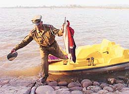 A police official takes out clothes of a couple who jumped into the Sukhna Lake from a pedal boat in Chandigarh