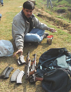 A policeman examining the arms and ammunition recovered from the slain terrorists