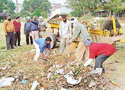 Garbage being sorted out in Sector 8, Chandigarh. Area councillor Chandermukhi Sharma and Medical Officer Health G.C. Bansal supervise the cleaning.