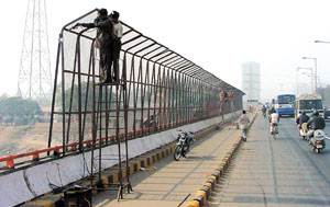 Protective fences being mounted on either side of the Yamuna Bridge