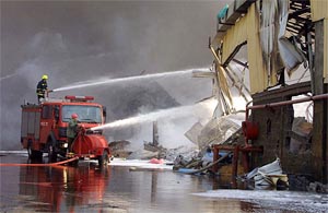 Firefighters spray water on a chemical factory in Haifa