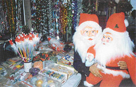 A Santa Clause holds his replica at a shop in Ghumar Mandi