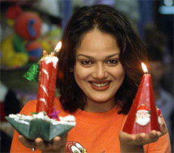 A model, Piu Sarkar, holds up Christmas candles