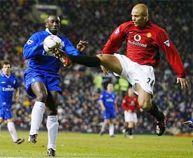 Manchester United's Wes Brown (R) clears the ball from Chelsea's Dutch striker Jimmy Floyd Hasselbaink
