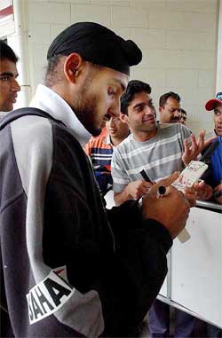 Harbhajan Singh signs autographs as the day's play gets called off due to bad weather on the first day of the second Test 