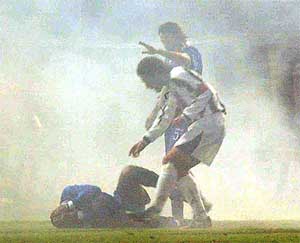 Smoke from a flare surrounds Como's Brazilian defender Juarez