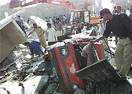 Police officers examine destruction caused by an explosion in Karachi on Thursday. A powerful explosion ripped through a chemical storage warehouse