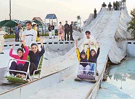 Youngsters go down a sledge in Fun City, near Panchkula