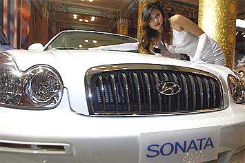A Chinese model poses next to a new Sonata passenger car
